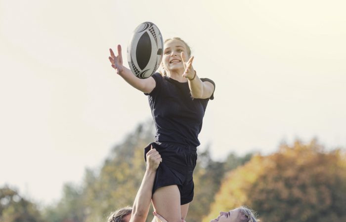 girl catching ball helped by her team mates